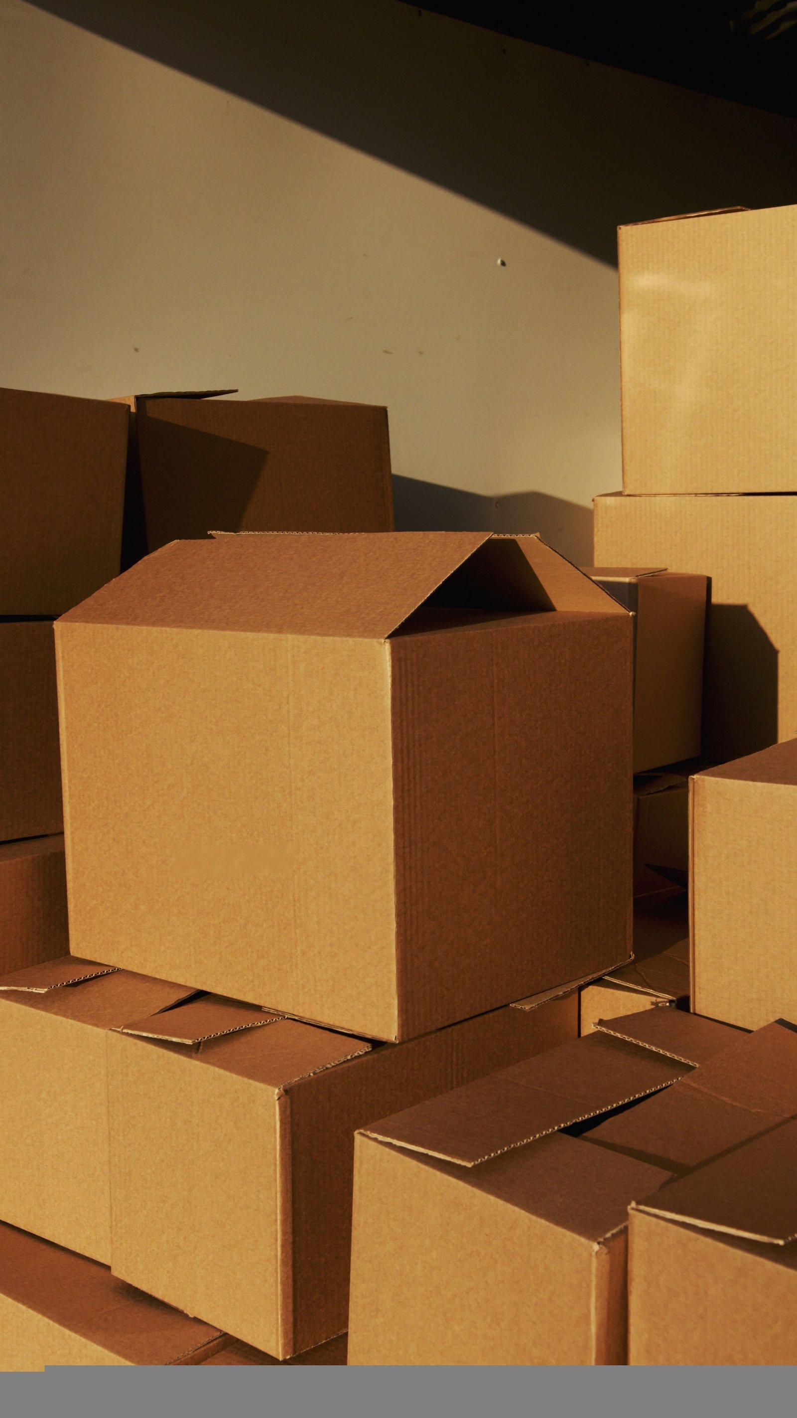 Unbranded corrugated boxes stacked in warm afternoon light