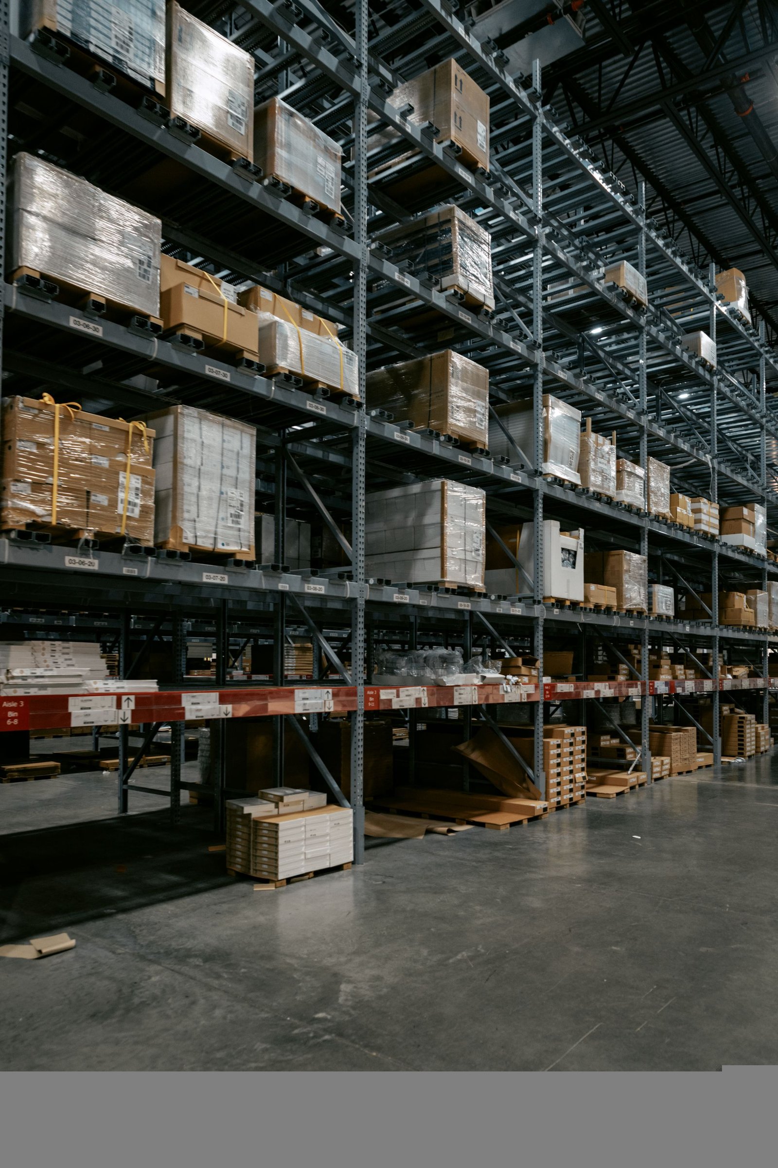 Industrial warehouse racks holding wrapped pallets and boxed merchandise